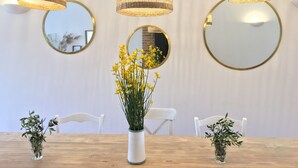 A dining area with a wooden table, three hanging wicker lamps, and three round mirrors on the wall. -  Bastide 1830, Domaine de la Bastidonne 4* Superb view of le Luberon Heated Pool (Céreste)
