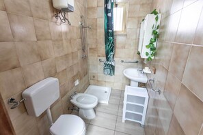 A small bathroom with a toilet, bidet, and sink. - Villetta Marta (Ugento)