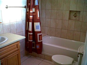 Une salle de bain avec une baignoire, des toilettes et un lavabo.