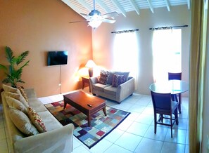 Relax in this stylish living room with a sofa, flat-screen TV, and dining area.