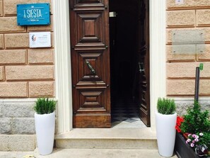 A wooden door with a plaque reading "A SIESTA LA MAQUAINE" and a sign for "GAIA INSTITUTE". - La Siesta (La Maddalena)