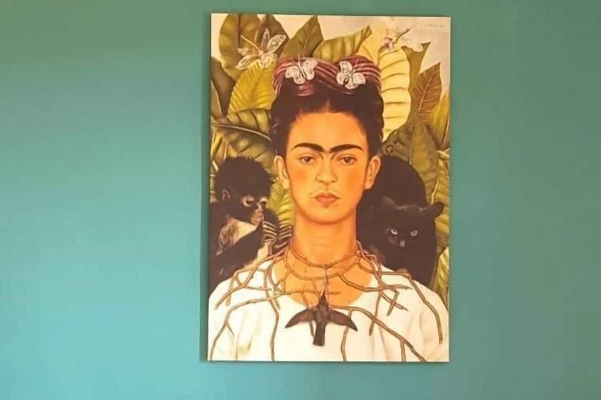 A painting of a person with a black cat on the wall.