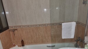 Un baño con bañera, lavamanos e inodoro.
