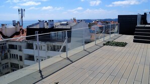 Une terrasse sur le toit offrant une vue sur le paysage urbain et la mer.
