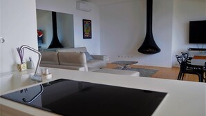 Une cuisine moderne avec un plan de travail noir, un évier blanc et un coin repas comprenant une table et des chaises.