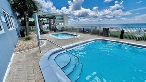 A pool area with two separate pools, a covered seating area, and a view of the ocean. - Asian Themed, Beach-Front, Penthouse Condo, Huge Balcony, Free Beach Chairs! (Panama City Beach)