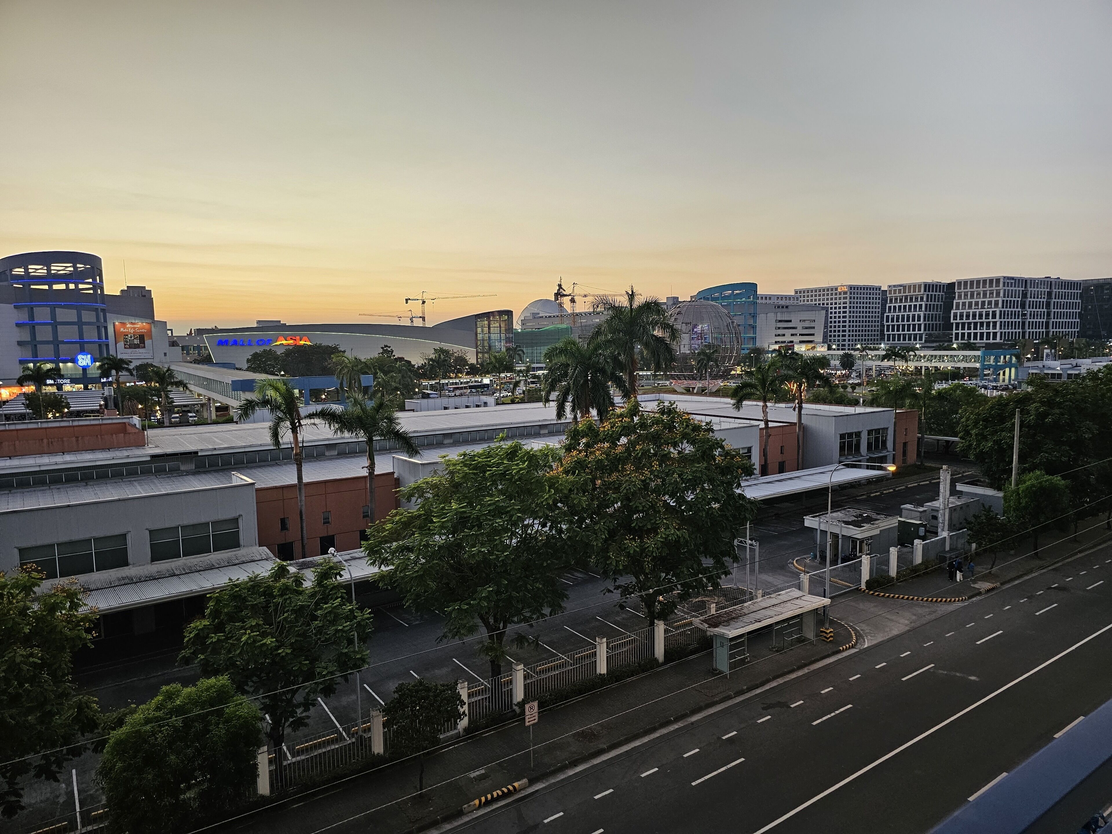 A cityscape with modern buildings, a parking lot, and a few trees.