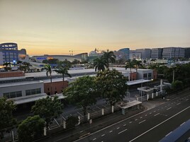 A cityscape with modern buildings, a parking lot, and a few trees.