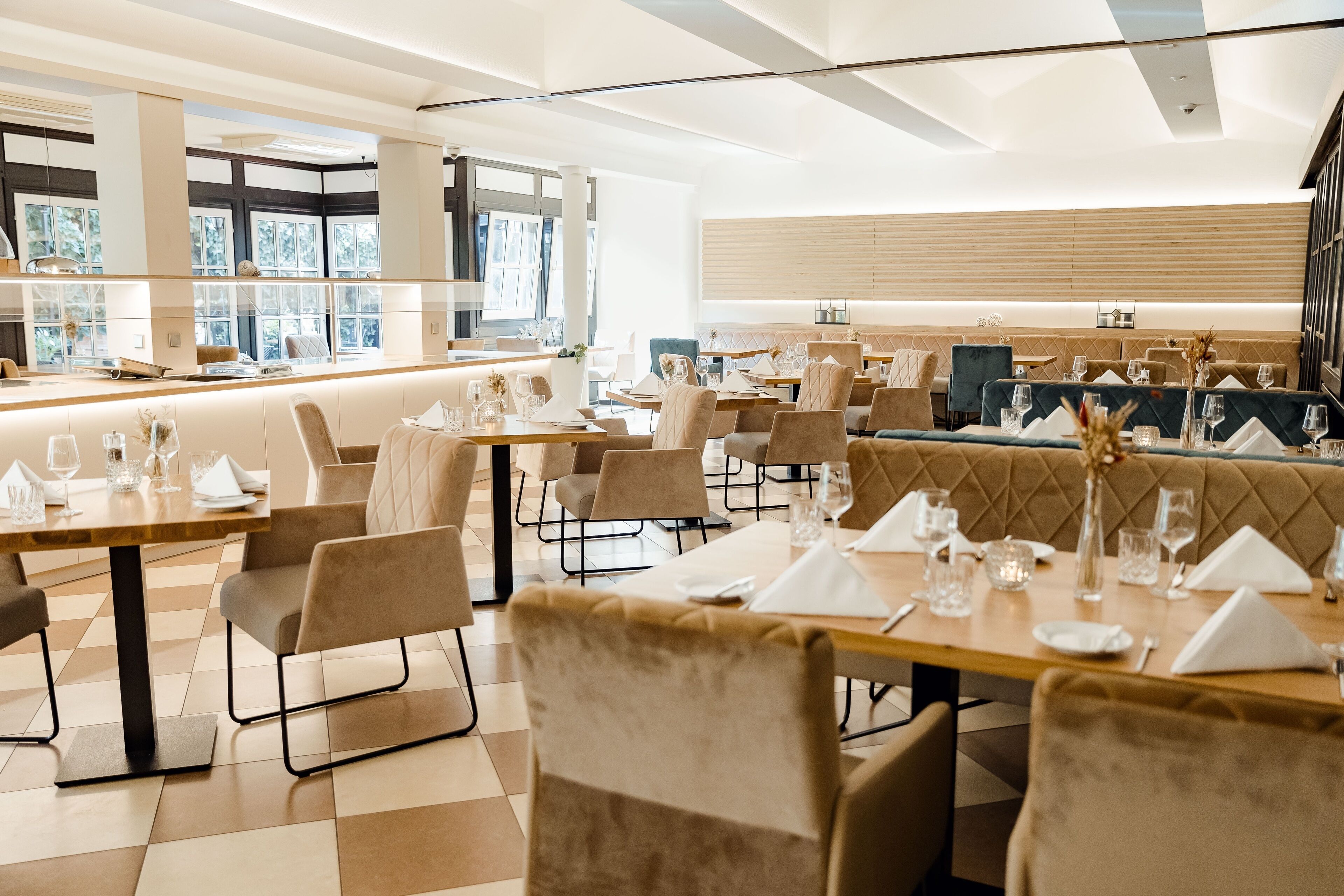 A modern dining area with multiple tables and cushioned seating.