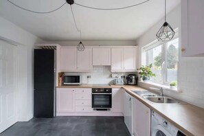 Casa básica, varias camas | Cocina privada | Microondas, horno, parrilla de estufa y utensilios de cocina