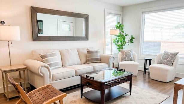 A living room with a sofa, armchairs, a coffee table, and a wooden bench.