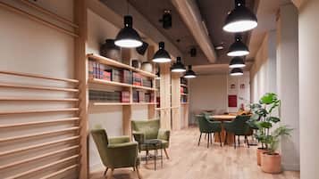 Eine moderne Bibliothek mit Holzbögen, grünen Sesseln und einem Holztisch.