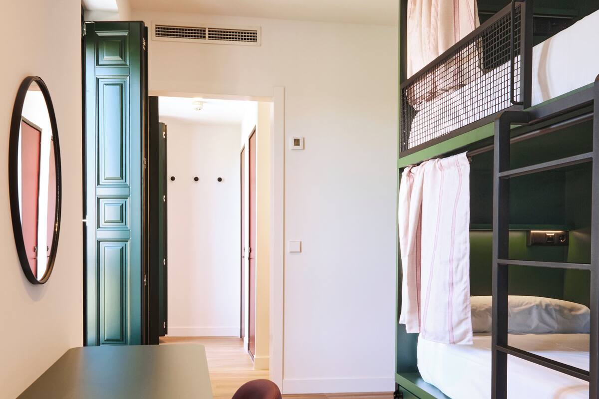 A room with a bunk bed, a desk, and a chair.