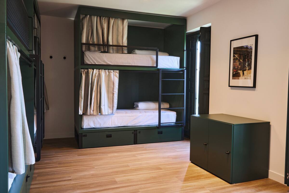 A bunk bed room with a wardrobe and a framed picture on the wall.