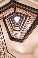 Eine Wendeltreppe mit einem Oberlicht in der Mitte, umgeben von einem Metallgeländer.