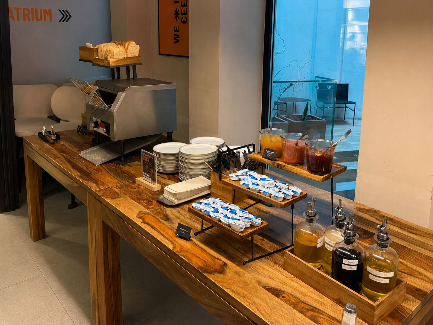 Un banco buffet con diversi cibi, piatti e condimenti.