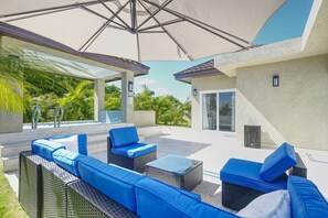 An outdoor patio with wicker furniture and a large umbrella. - Modern 3 bedrooms with king size bed and hot tub (Montego Bay)