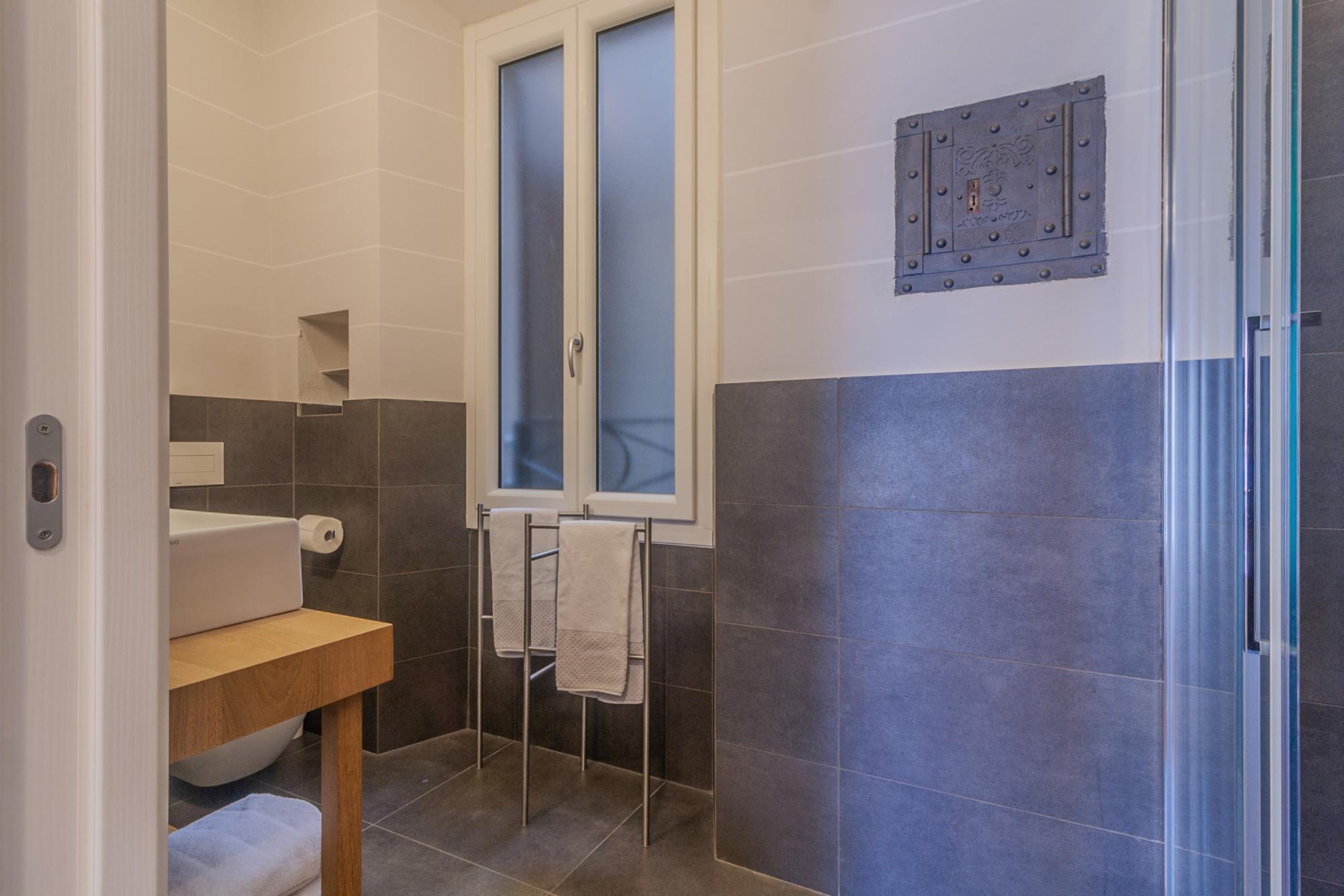 A bathroom with a toilet, sink, and towel rack.