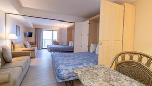 A room with a bed, a sofa, a dining table, and a chair. - Oceanfront Efficiency direct ocean views pool, gym & near all (Ocean City)