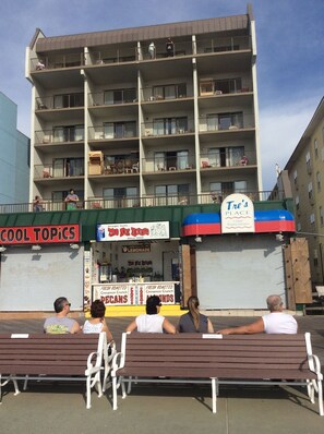 A multi-story building with balconies, a sign for 'Tre's Place' with a unique shopping experience, and a closed shop named 'The Hot Upside' selling lemonade and snacks.