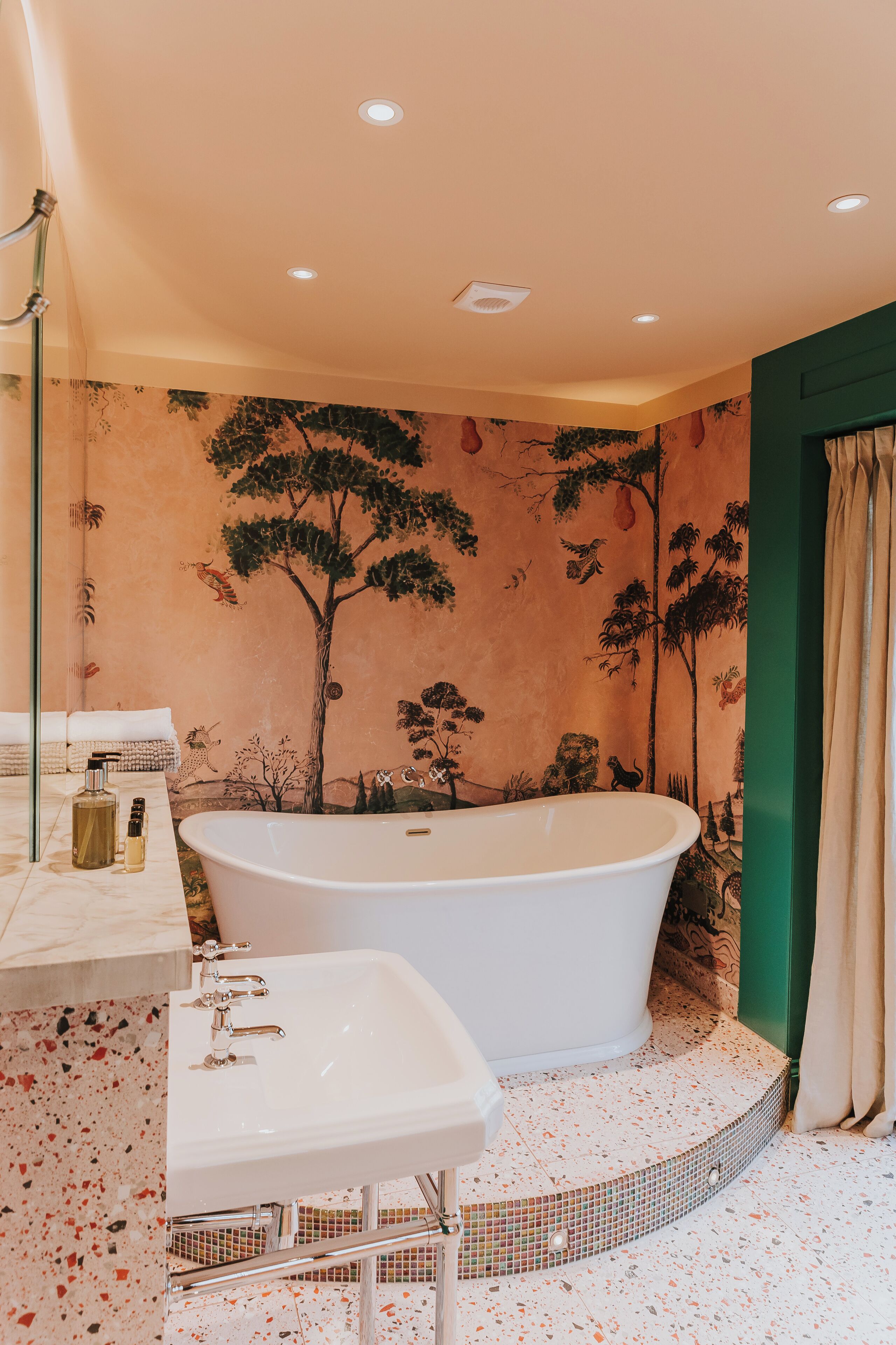 Une salle de bain avec une baignoire sur pieds, un lavabo et un miroir.