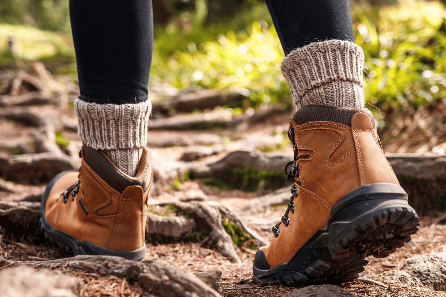 Wanderschuhe mit profilierter Sohle, braunem Obermaterial und schwarzem Riemen.