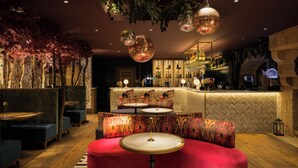 Un espace bar avec un comptoir, des sièges et un plafond décoratif.