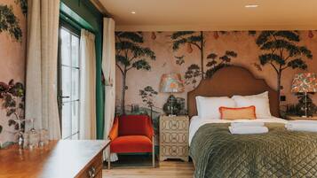 A hotel room with a bed, a nightstand, a chair, and a dresser.