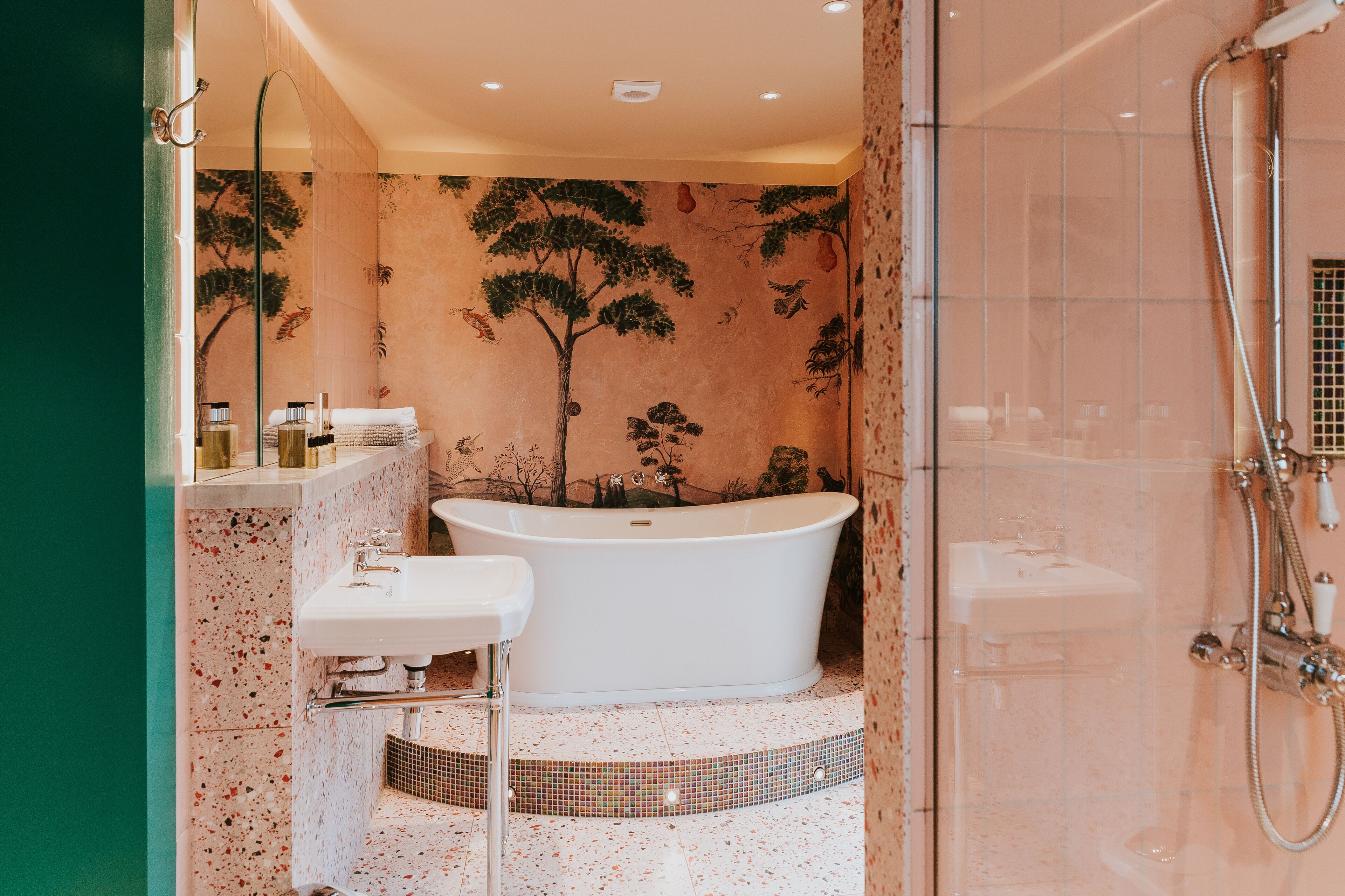 A bathroom with a freestanding bathtub, a sink, and a shower area.