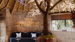 Un mur de pierre avec un plafond en bois et une enseigne sur laquelle on peut lire « THE TEMPUS ».