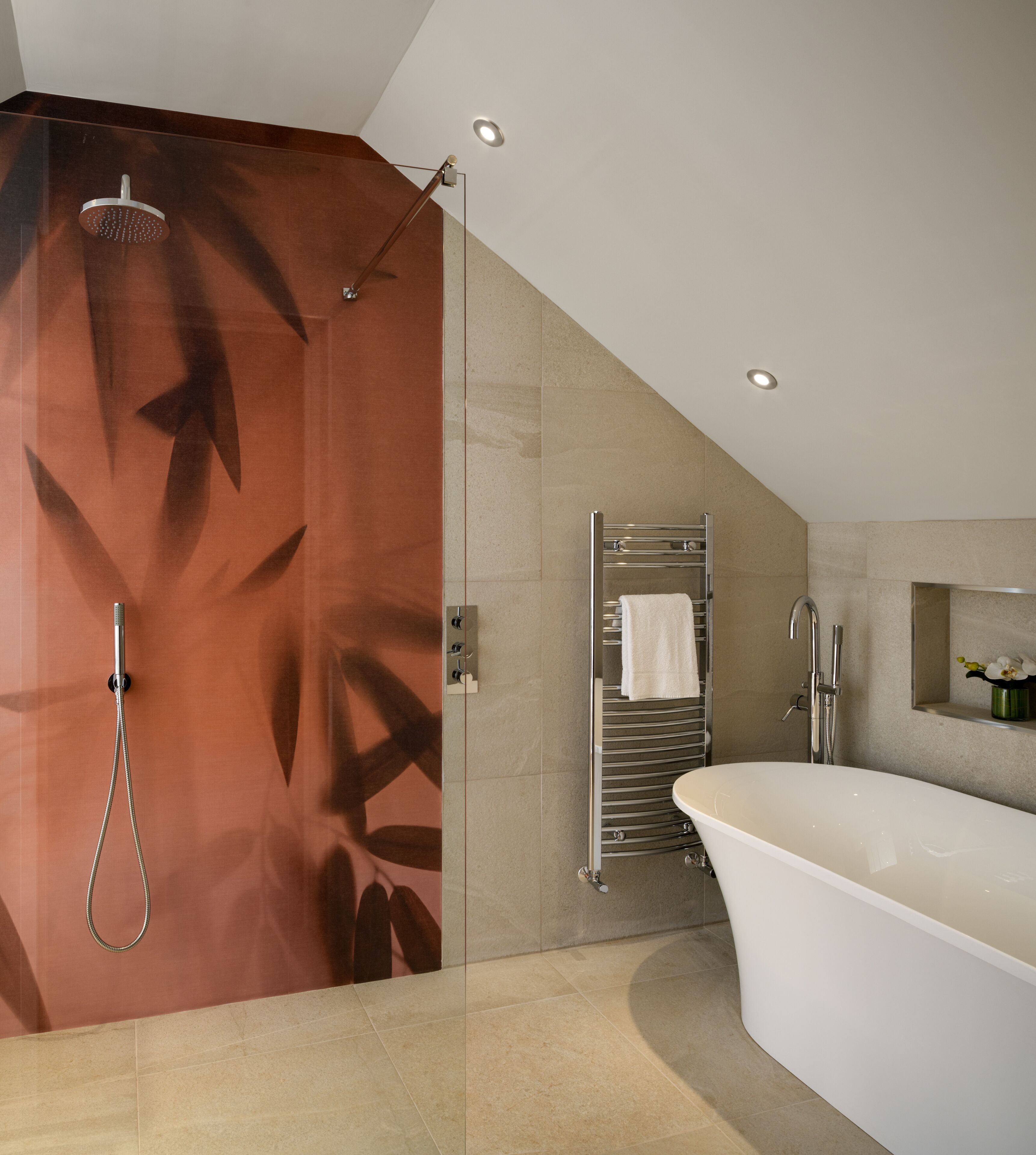 Een moderne badkamer met een vrijstaand bad, een douche met glazen wanden en een handdoekhouder.