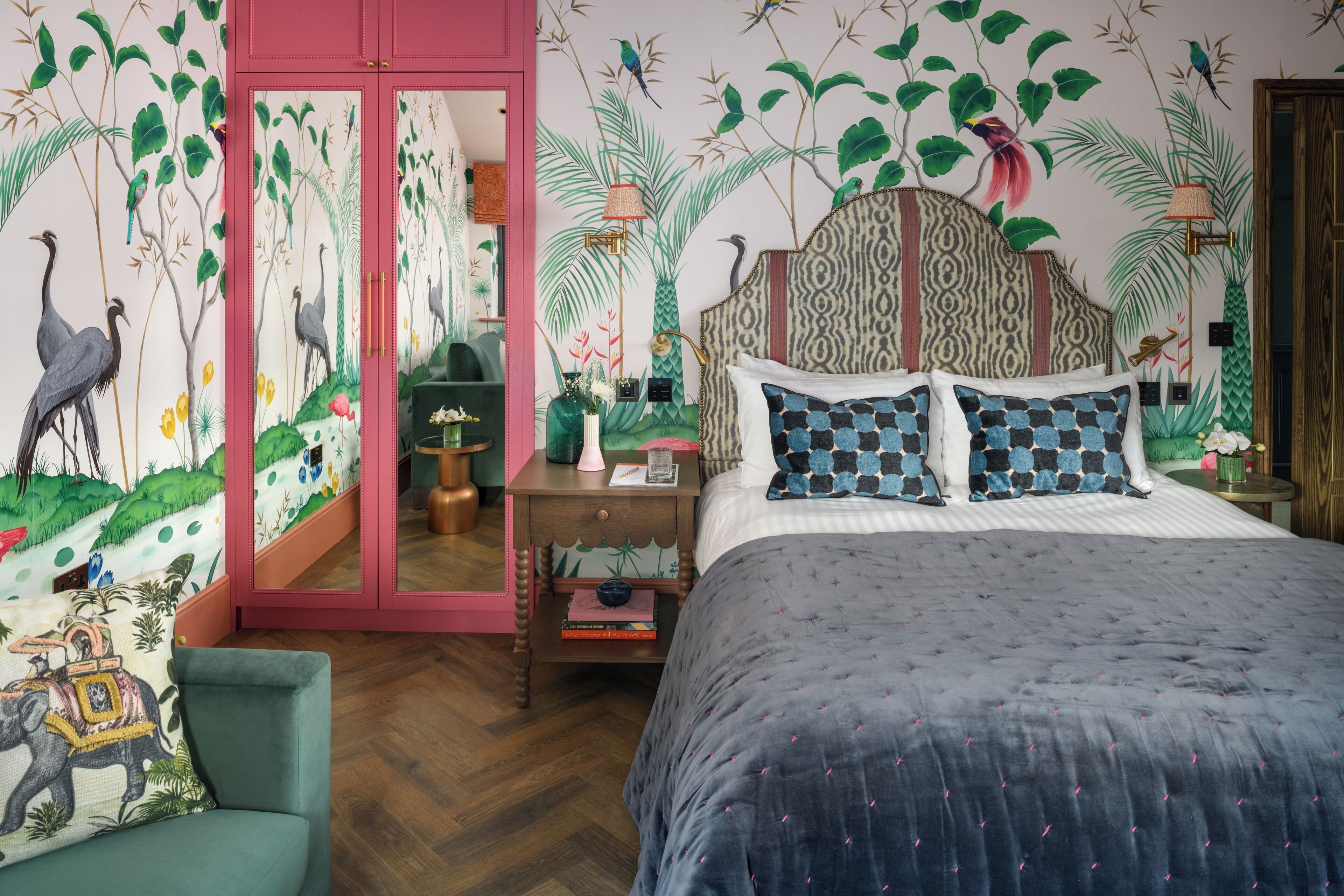Une chambre à coucher avec un lit, une table de chevet, une chaise et un miroir.