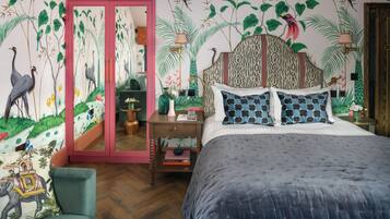 Un dormitorio con cama, mesita de noche, silla y espejo.