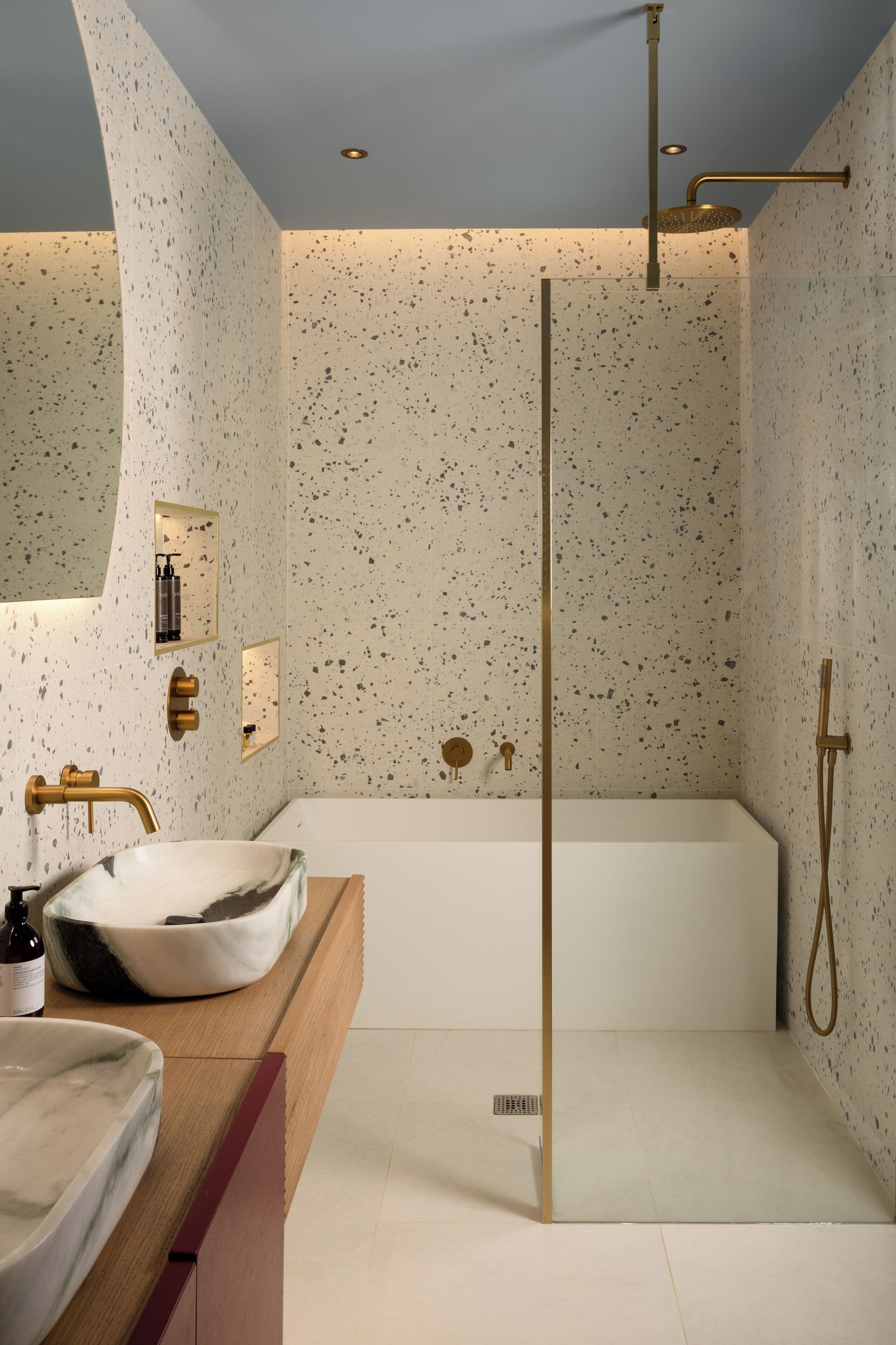 Ein modernes Badezimmer mit einer freistehenden Badewanne, einem großen Spiegel und einem мраморня Waschbecken.