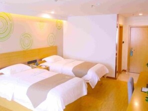 A hotel room with two beds, a wooden headboard, a desk with a chair, and a door. - Greentree Inn Nantong Qidong Binhai Industrial Park Zone Nanhai Road Express Hotel (Nantong)