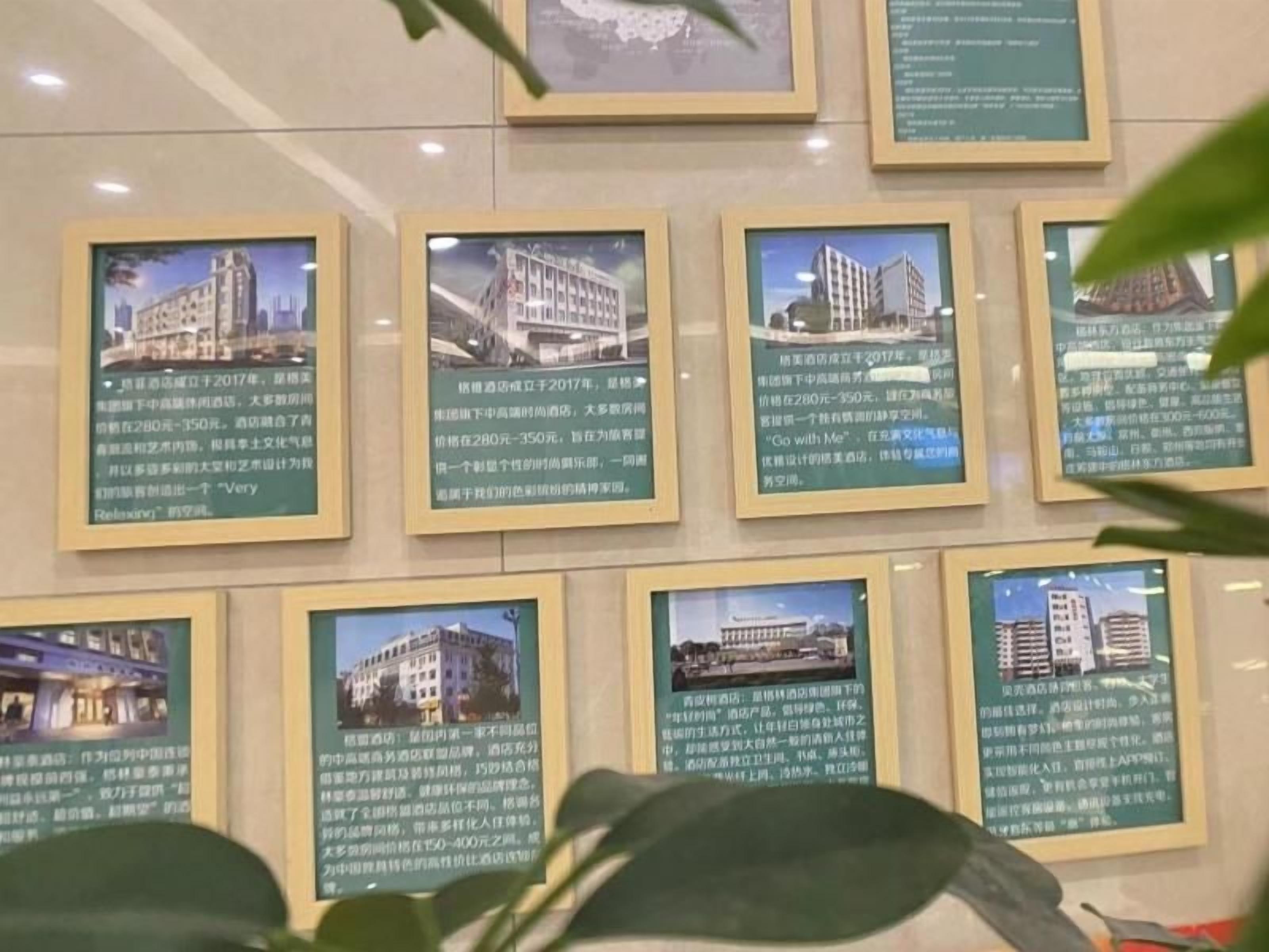Eine Wand mit gerahmten Bildern von Gebäuden, jedes mit begleitendem Text.