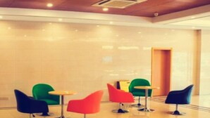 A lobby with a polished floor, a reception desk, and colorful chairs. - Greentree Inn Nantong Qidong Binhai Industrial Park Zone Nanhai Road Express Hotel (Nantong)