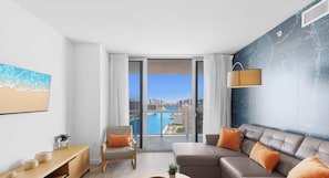 A modern living room with a city view, a sofa, a chair, and a small table.