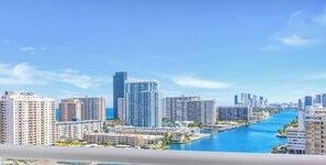 A cityscape with a river, high-rise buildings, and a clear sky.