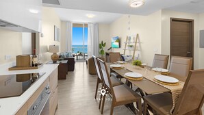 Een moderne keuken met een eethoek, uitzicht op zee en een gezellige zithoek.