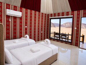 A hotel room with two beds, a large window with a desert view, and a red patterned wall. - Shaheen Camp wadi rum (Wadi Rum)