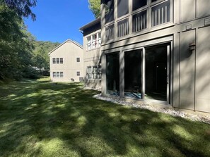 A modern two-story building with large sliding glass doors and a well-maintained lawn. - 14080 Mountain View | First Floor Condo! (Mercersburg)