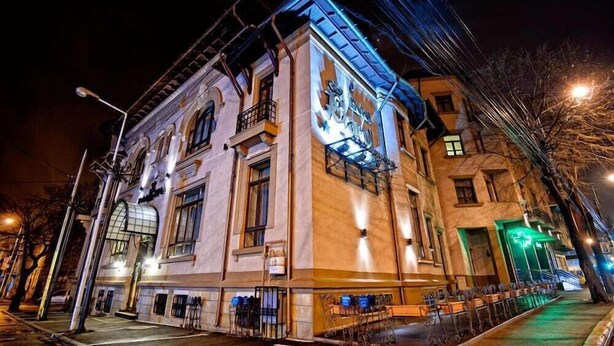 Un edificio histórico con una entrada destacada y un balcón.