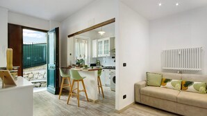 Un espacio abierto que combina la sala de estar y la cocina, con un sofá, una mesa de comedor y sillas.
