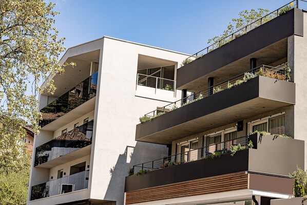 Un edificio de varios pisos con balcones, ventanas amplias y un estilo arquitectónico moderno.