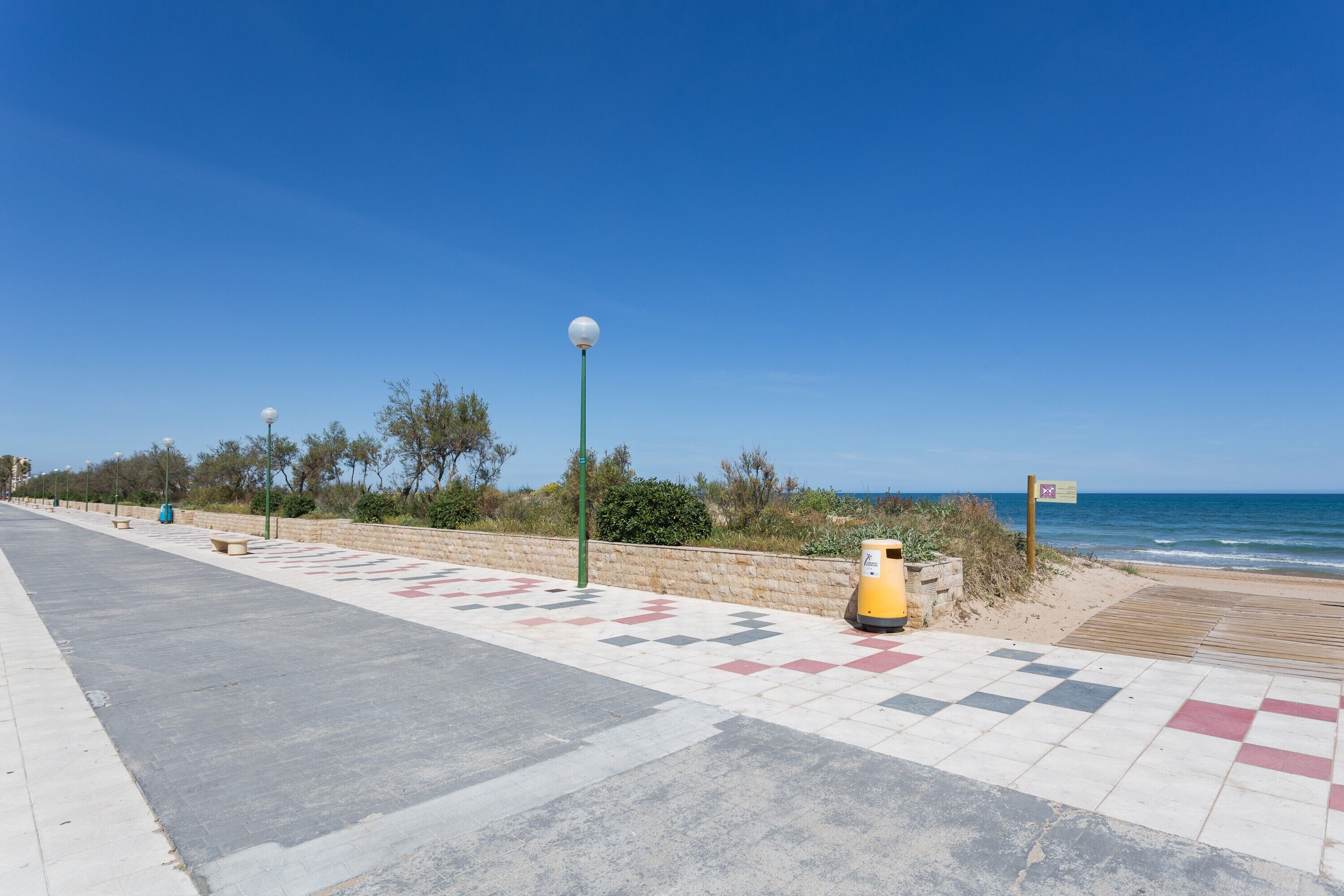 Un passeig marítim amb un dibuix de graons, un fanal i un safata de brossa.