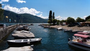 Una marina con barche ormeggiate, un molo e montagne sullo sfondo.