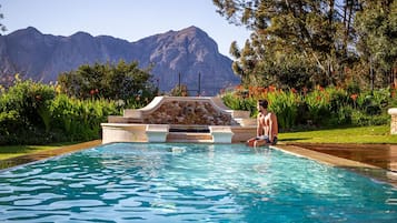 Una piscina al aire libre, sombrillas, tumbonas