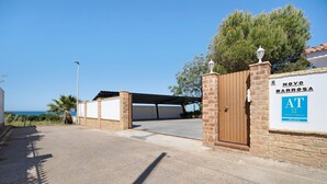Ein verschlossenes Eingangstor zu einem Anwesen namens 'Novo Barrosa', im Hintergrund ist die See deutlich sichtbar.