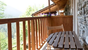 A wooden deck with a bench and a table, overlooking a mountainous landscape. - Chalet 'Civico 5' with Mountain View, Shared Garden and Wi-Fi (Marmora)